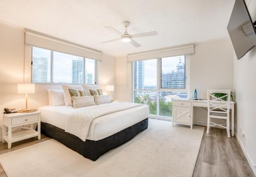 a white bedroom with a large bed and windows at Xanadu Resort in Gold Coast
