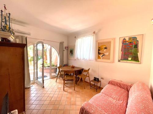 a living room with a couch and a table at Casa Captain Howard Blackburn - fronte mare con giardino - Santa Teresa di Gallura in Santa Teresa Gallura