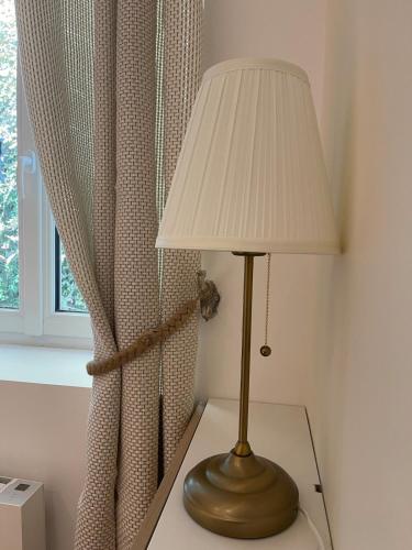 a lamp sitting on a table next to a window at La maison du Manoir 1900 in La Ferté-Gaucher