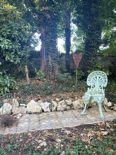a white bench sitting on a stone path with a heart sign at La maison du Manoir 1900 in La Ferté-Gaucher