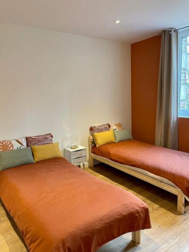a room with two beds in a room at La maison du Manoir 1900 in La Ferté-Gaucher