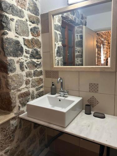 Un baño con un lavabo blanco y un espejo. en Lithos Family Apartment, en Kalymnos