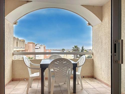 une table et des chaises sur un balcon avec vue dans l'établissement Le Thalio - Swimming pool - Air conditioning, à Gruissan