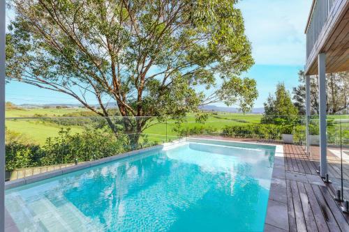 a swimming pool in the backyard of a house at Wave and Willow Luxury Family Retreat in Jamberoo