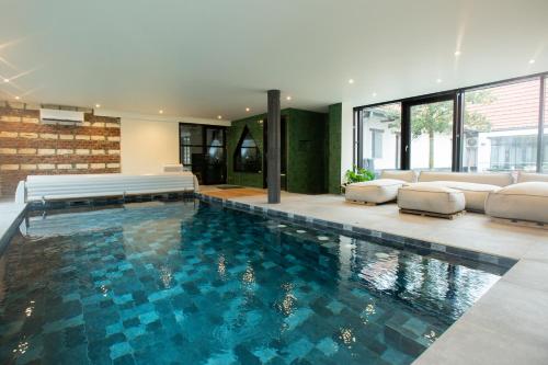 une grande piscine dans une maison dans l'établissement Cabanon à la FERME1802, à Sainghin-en-Mélantois