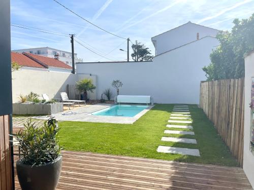 une cour avec une piscine et une clôture en bois dans l'établissement Villa Georgette, à Saint-Gilles-Croix-de-Vie