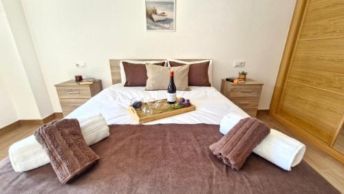 a bedroom with a large bed with a tray of food at Apartamentos Pedras do Val in Mondariz