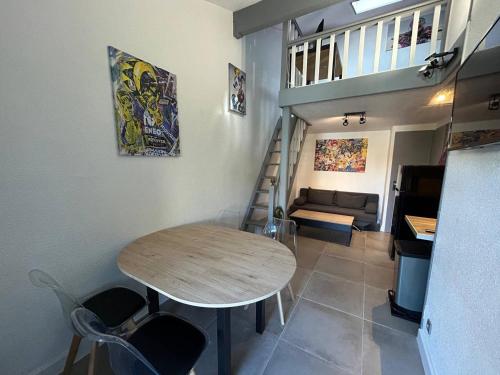 une chambre avec une table, des chaises et un escalier dans l'établissement Coul, à Valras-Plage