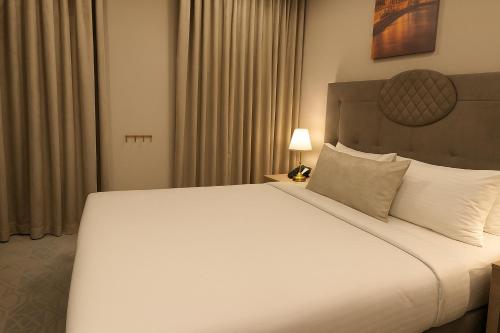 a large white bed in a hotel room at Saraya Palace Hotel in Doha