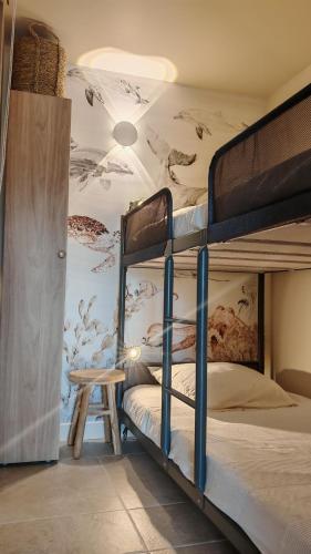 une chambre avec deux lits superposés avec une fresque murale dans l'établissement Jolie Maisonnette vençoise, à Vence
