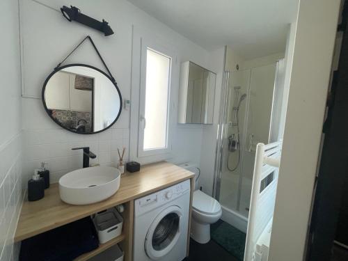 une salle de bain avec un lavabo et une machine à laver dans l'établissement Petit goéland, à La Grande Motte