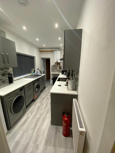 a large kitchen with a washer and dryer at Victoria Homes in Stoke on Trent