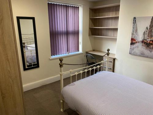 a bedroom with a bed and a window and a mirror at Victoria Homes in Stoke on Trent