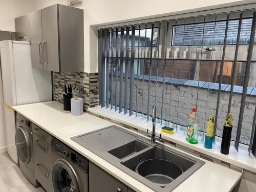 a kitchen with a sink and a window at Victoria Homes in Stoke on Trent
