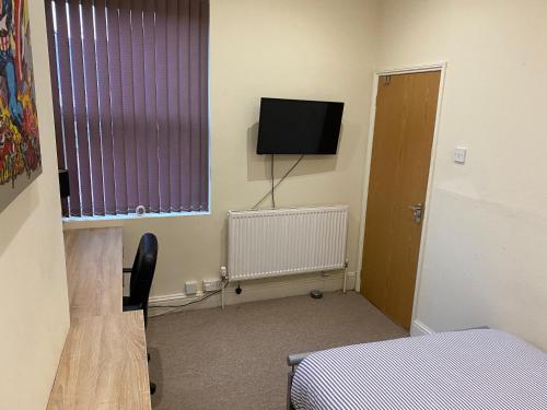 a room with a bed and a tv and a window at Victoria Homes in Stoke on Trent
