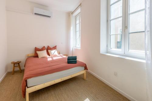a bed in a white room with a window at Pause méditerranéenne en plein centre in Béziers