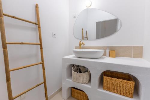 a bathroom with a white sink and a mirror at Pause méditerranéenne en plein centre in Béziers