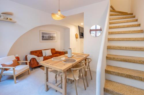 une salle à manger avec une table et des chaises et des escaliers dans l'établissement Pause méditerranéenne en plein centre, à Béziers