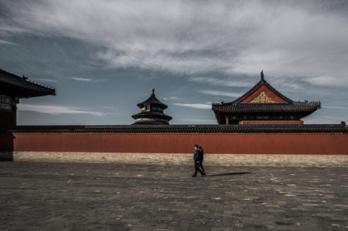 a man walking in front of a building at YOYO PINKE Hotel in Beijing