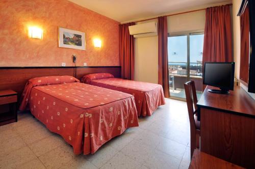Una habitación de hotel con dos camas y un televisor. en BLUESEA Continental, en Tossa de Mar