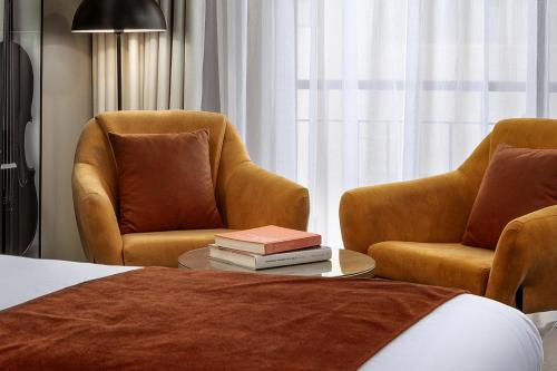 a hotel room with two chairs and a table with books at Vivaldi Hotel in St Julian's