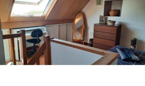 une chambre mansardée avec un miroir et une commode et un miroir dans l'établissement CHARMANTE PETITE MAISON BRETONNE T1bis vue mer et nature, à Plougonvelin