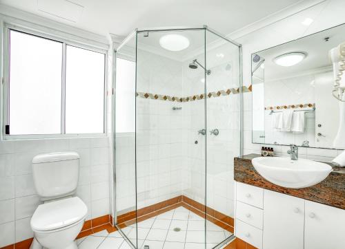 a bathroom with a shower and a toilet and a sink at Xanadu Resort in Gold Coast