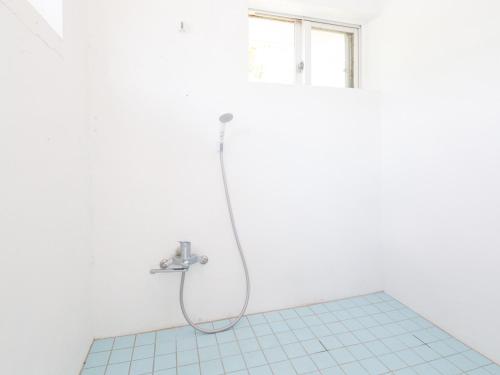 a shower in a bathroom with a tile floor at Sun Green Resort Hotel Ishigaki in Ishigaki Island