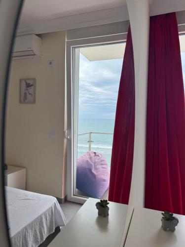a bedroom with a window with a view of the ocean at Deluxe Apartments Shengjin in Shëngjin