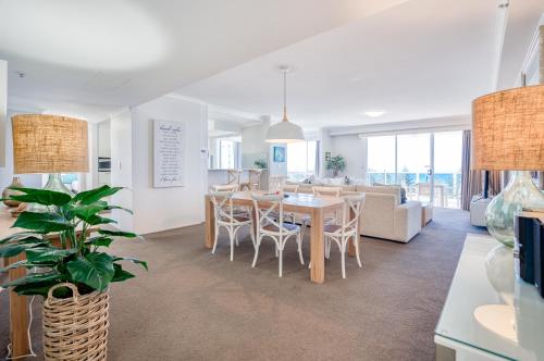 a dining room and living room with a table and chairs at Xanadu Resort in Gold Coast
