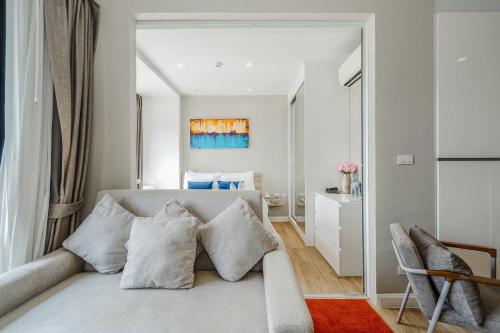 a living room with a couch with pillows at C176 Diamond Paradise Getaway Condo Phuket in Bang Tao Beach