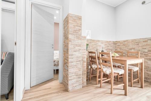 a dining room with a table and a brick wall at Accogliente e moderno Bivani a 2 minuti a piedi dalla spiaggia-centro con parcheggio riservato in Giardini Naxos