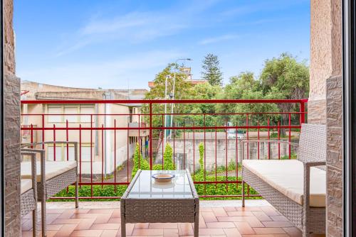 a balcony with a table and a view of a building at Accogliente e moderno Bivani a 2 minuti a piedi dalla spiaggia-centro con parcheggio riservato in Giardini Naxos