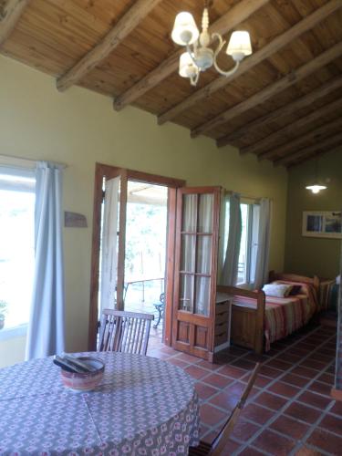 a room with a table and a bed and a bedroom at Complejo Dulcería El Cazador y cabañas in Tandil