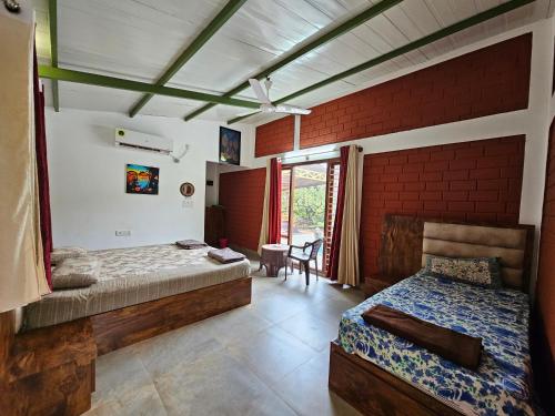 a bedroom with two beds and a ceiling fan at Farmhouse with Pool - Kalavady Farmstay in Baindūru