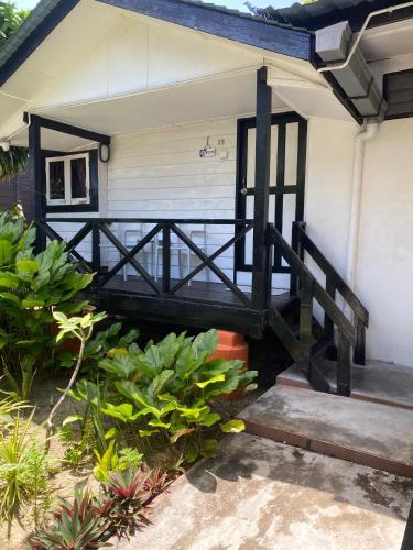 a porch of a house with a gate and some plants at Nipah Bay Villa in Pangkor