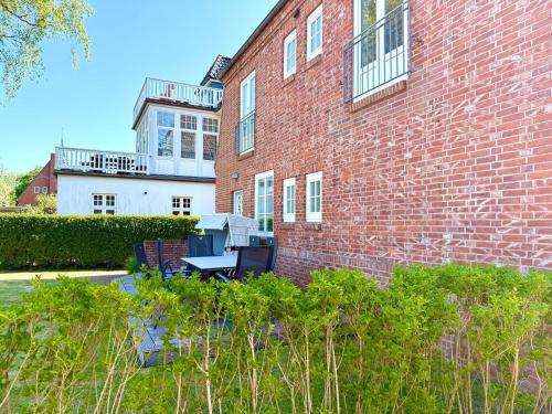 un edificio de ladrillo con una mesa delante en Dat Stadthus, en Wyk auf Föhr
