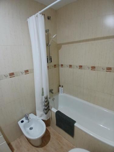 a bathroom with a white tub and a toilet and a sink at Bonito piso de 2 habitaciones in Híjar