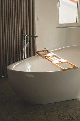 a white bath tub in a bathroom with a window at L'olive homes in Marmaris
