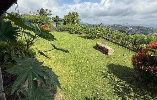 a yard with green grass and a fence at Namadi heights Bungalow in Kandy
