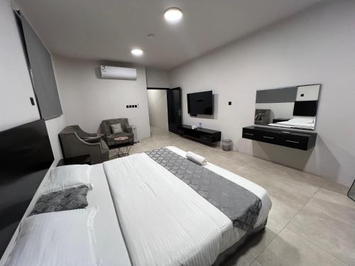a bedroom with a large bed and a television at شقق السابعة السكنية in Buraydah