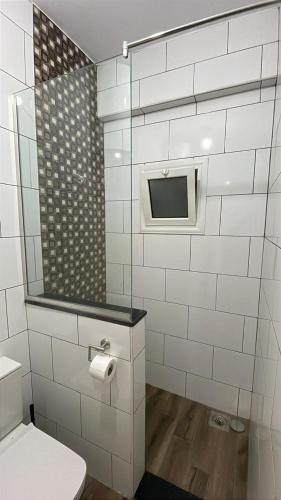 a bathroom with a toilet and a tv on the wall at Sage House Lighthouse & Assalah in Dahab