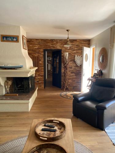 a living room with a couch and a fireplace at Villa piscine chauffée & spa sur le Bassin d Arcachon - proche plage et océan in Lanton