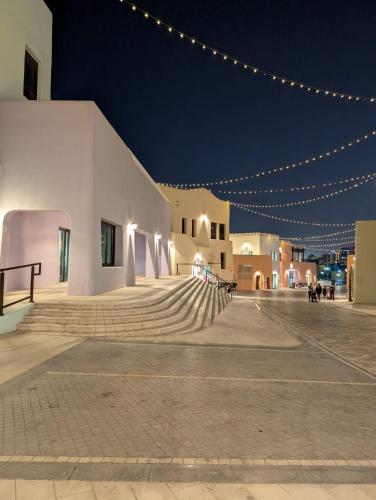 a building with stairs and lights at night at Saraya Palace Hotel in Doha