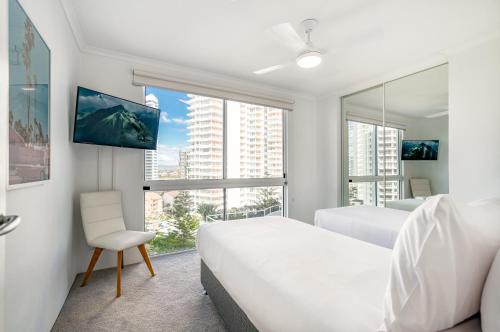 a white bedroom with a bed and a window at Xanadu Resort in Gold Coast