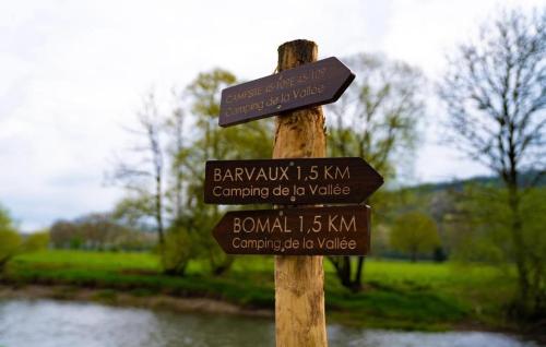 a wooden sign with several signs on a wooden pole at bell tent in Durbuy