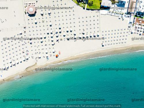 an aerial view of a beach with umbrellas at Accogliente e moderno Bivani a 2 minuti a piedi dalla spiaggia-centro con parcheggio riservato in Giardini Naxos