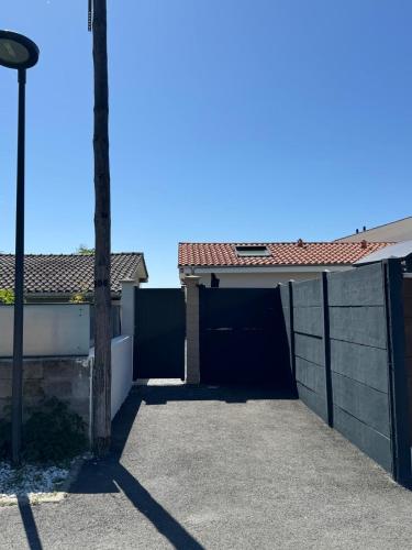a garage in a house with a fence at Mon Cocon Bordelais in Villenave-dʼOrnon