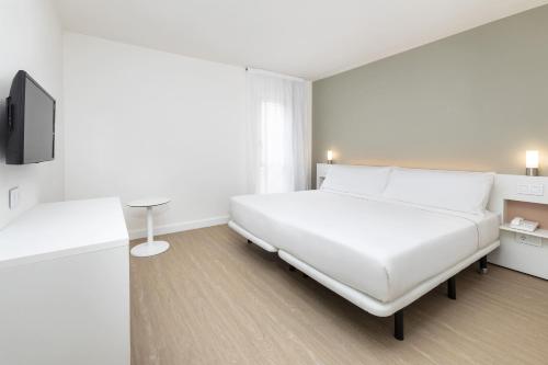 a white bedroom with a bed and a tv at Sol Fuerteventura Jandia - All Suites in Morro del Jable