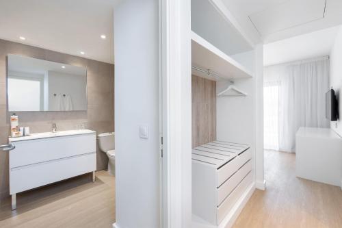 a white bathroom with a sink and a toilet at Sol Fuerteventura Jandia - All Suites in Morro del Jable